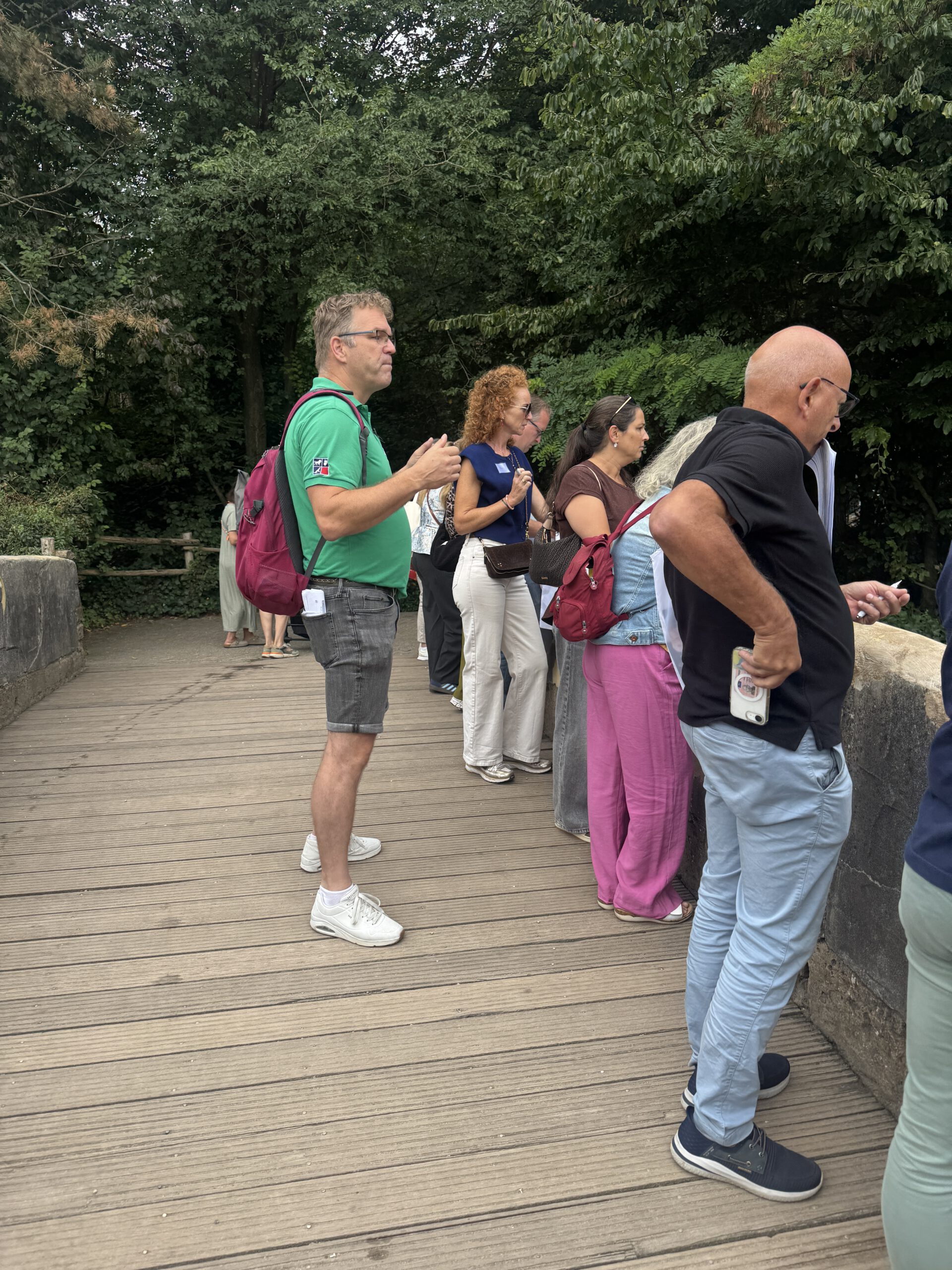 Deelnemers van een teamworkshop kijken samen naar dieren in de dierentuin